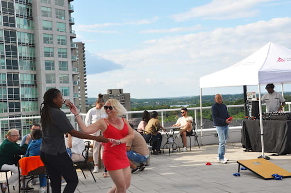 two women dancing at an event on the roof of a building