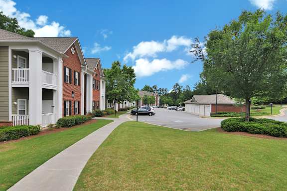 A sunny day in a quiet residential area with houses on both sides of the street.