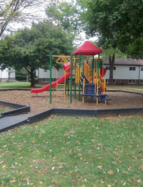 a childrens playground with a slide in a park