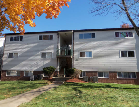 an apartment building with a sidewalk in front of it