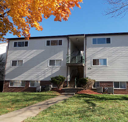 an apartment building with a sidewalk in front of it