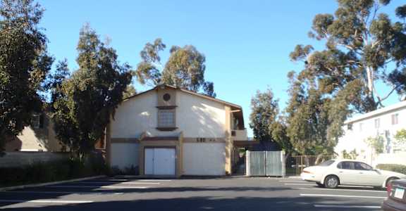 a white building with a garage in a parking lot