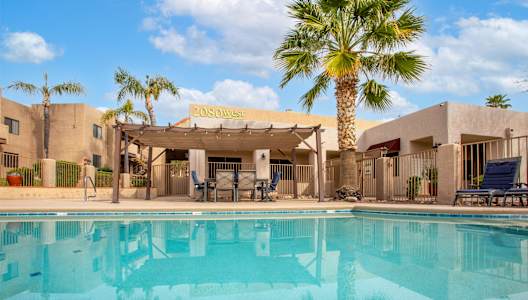 A pool in front of a building with a palm tree.