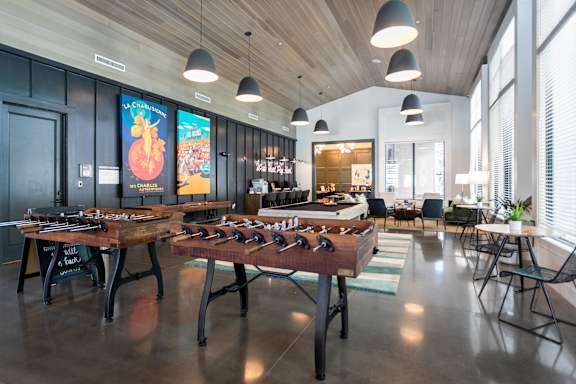 a recreation room with foosball tables and chairs