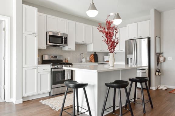 a kitchen with a center island with three stools