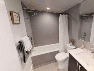 A white toilet sits next to a white sink in a small bathroom.