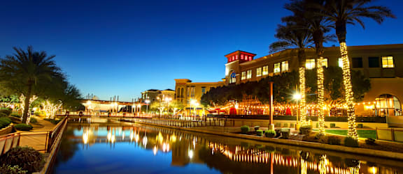 a city at night with lights on the water