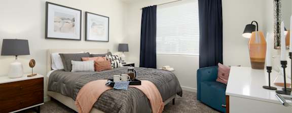 A bedroom with a large bed and a nightstand.