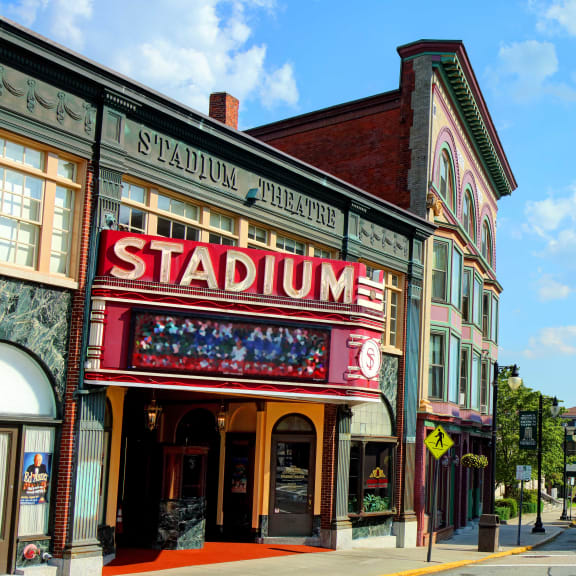 the marquee of the stadium theater on the corner of a city street
