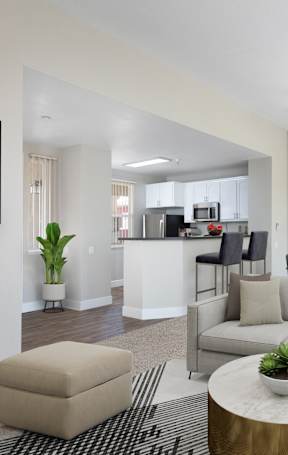 A living room with a grey couch, a coffee table, and a ceiling fan.