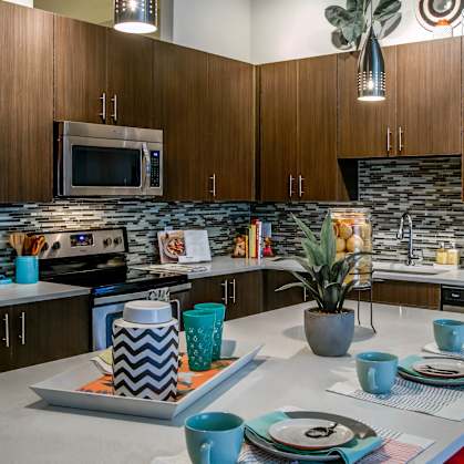 A modern kitchen with a white countertop and blue cups.
