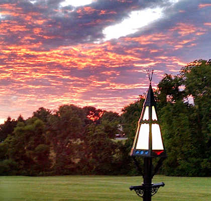 A beautiful sunset with a sailboat in the foreground.