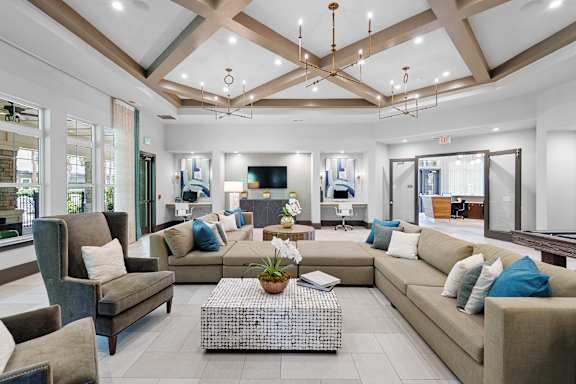 A spacious living room with a variety of seating options and a coffee table in the center.