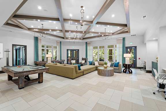 A large, well-lit room with a pool table and comfortable seating.