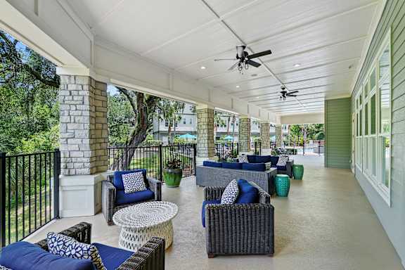 A patio with a black railing and furniture.
