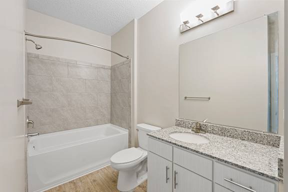 A white bathroom with a toilet, sink, and bathtub.