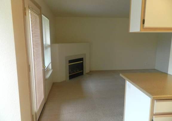 A room with a fireplace and a window with blinds.