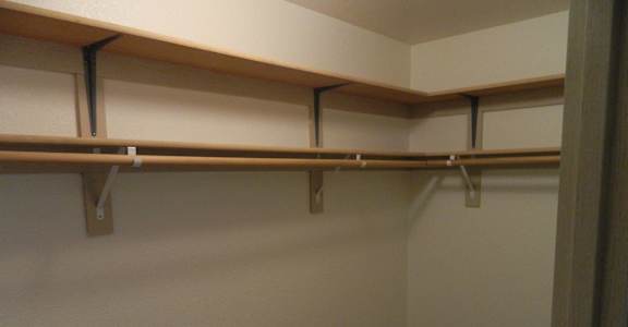 A room with a carpeted floor and a wall with shelves.