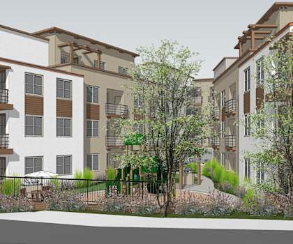 A modern apartment complex with balconies and trees in front.