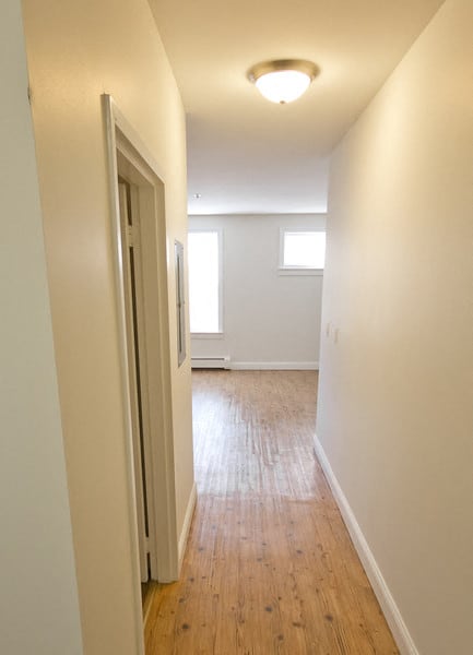 hallway leading to living room with hardwood floors