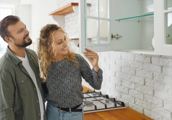 a man and woman standing in a kitchen at Palm Cove Apartments, Daytona Beach, FL 32114
