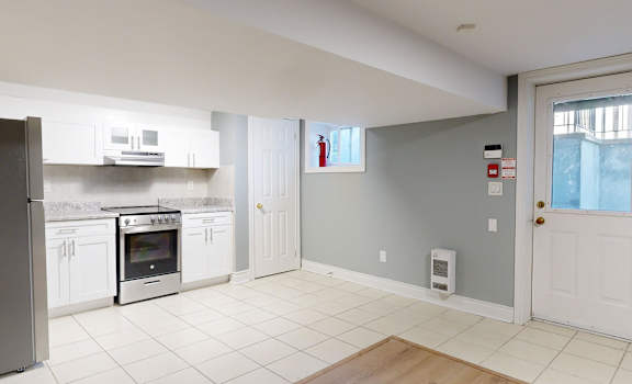 A kitchen with a refrigerator, oven, and microwave.