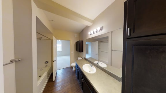a bathroom with two sinks and a tub and a shower