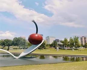 a sculpture of a spoon with a cherry on top of it