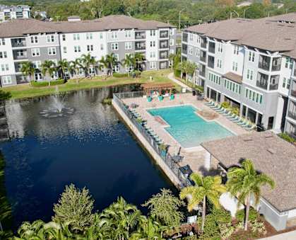 A large swimming pool is surrounded by apartment buildings.