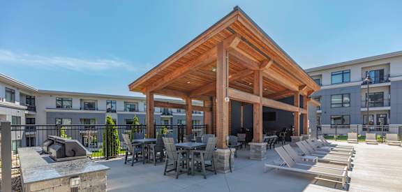a covered patio with tables and chairs and a fire pit at Two Points Crossing, Madison, WI, 53593