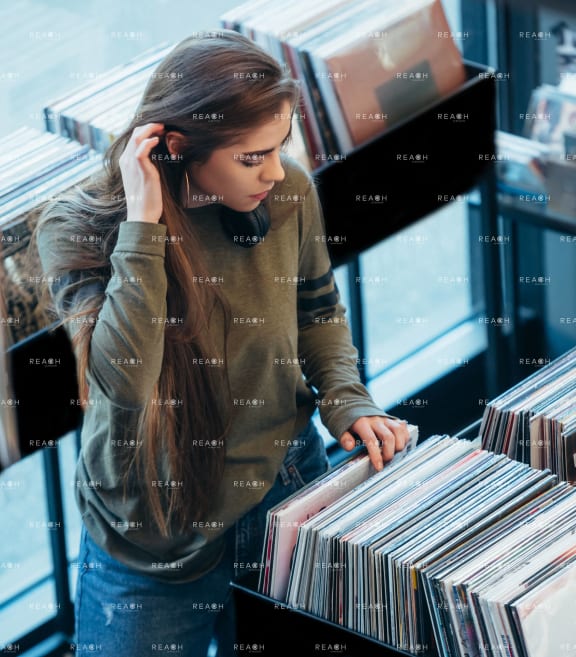 a girl looking at records in a record store