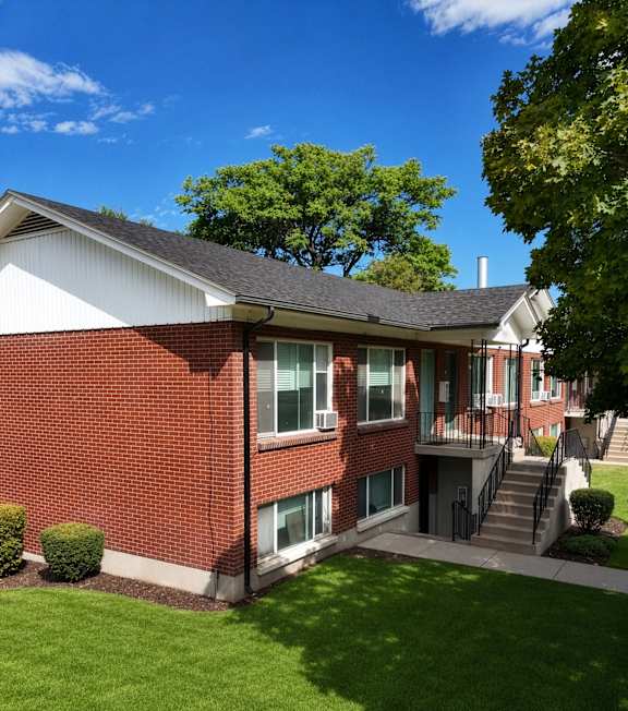 A red brick house with a green lawn in front.