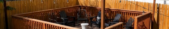 A wooden deck with a hot tub in the middle of a grassy area.