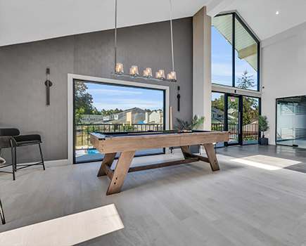 A modern living room with a wooden bench and a view of the backyard through the sliding glass doors Townhomes at Gateway, Bensalem, Pennsylvania