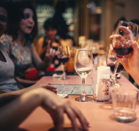 a group of people sitting around a table with wine glasses