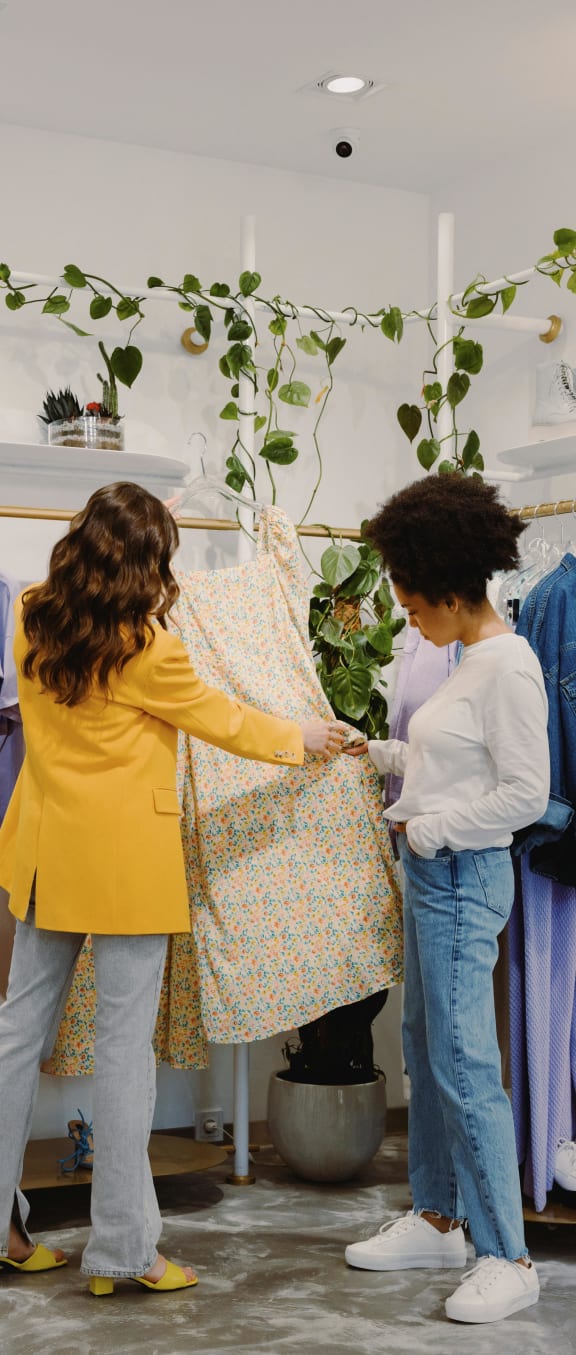two women looking at a dress in a clothing shop