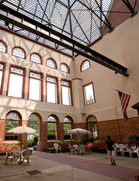 a large building with a glass ceiling and a courtyard with tables and chairs