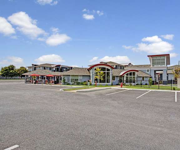 The parking lot in front of the light blue and red leasing office at Solara Apartment Homes. 