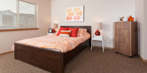 a bedroom with a bed and a dresser and a window