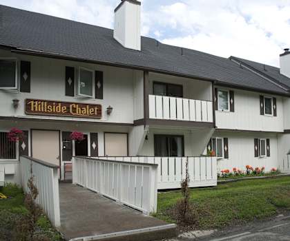 A white building with a sign that says Hillside Chalet.