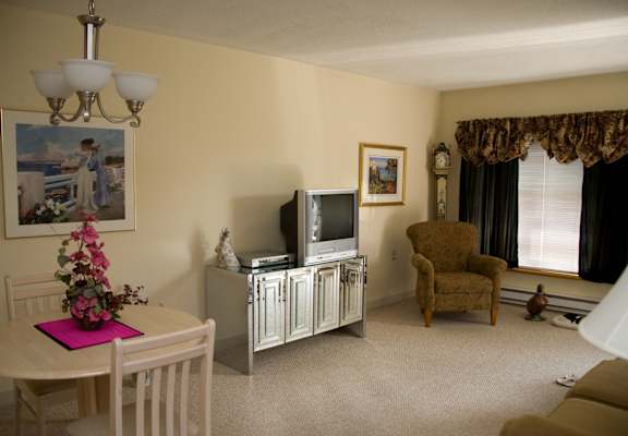 a living room with a tv and a table and a chair