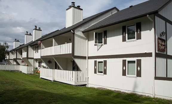 A white building with a sign that says "Pine Hollow Inn".