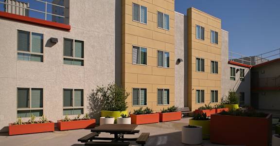the courtyard of an apartment building with a picnic table