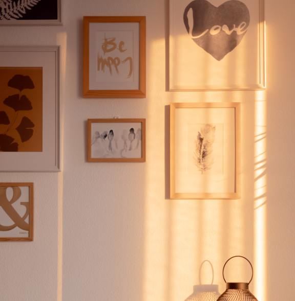 a shelf with two lanterns and pictures on the wall