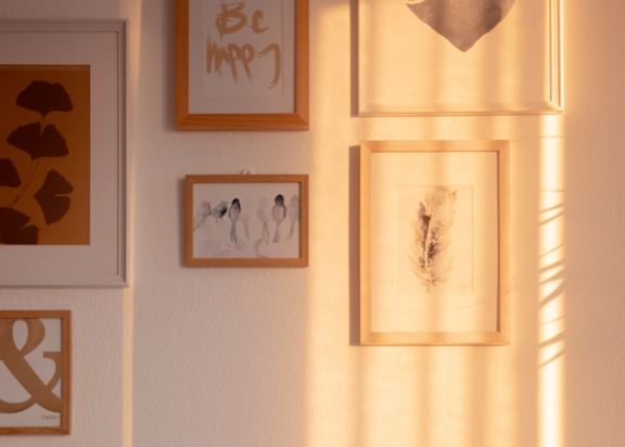 a shelf with two lanterns and pictures on the wall