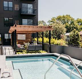 A small pool with a metal railing and a wooden pergola.