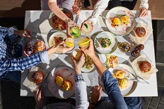 A group of people are sitting around a table with plates of food.
