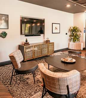 A living room with a flat screen TV mounted on the wall.