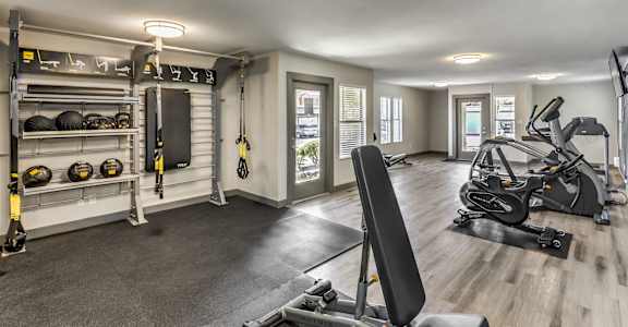 a home gym with weights and equipment and a door to a balcony
