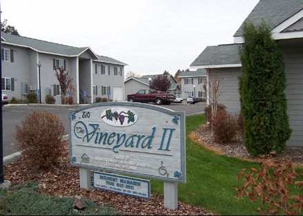 a sign for emerald ii in front of some houses